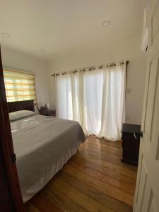 a bedroom with a bed and white curtains at Ocean breeze Villas in La Ceiba