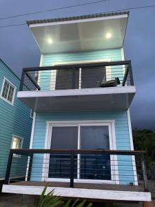 a blue house with a balcony in front of it at Ocean breeze Villas in La Ceiba