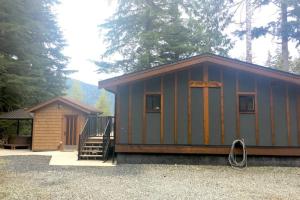 a small cabin with a staircase next to a house at The Great Escape - Port Renfrew in Port Renfrew