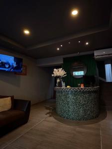 a lobby with a bar with a couch and a tv at Hotel Puerta de Jade in Ciudad Valles