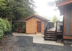a wooden cabin with a porch and a gazebo at The Great Escape - Port Renfrew in Port Renfrew