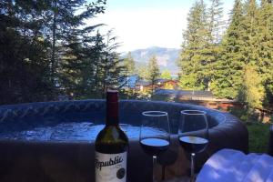 a bottle of wine and two glasses on a table at The Great Escape - Port Renfrew in Port Renfrew