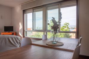 a dining room table with a vase of flowers on it at Laxes do Mar in Baiona