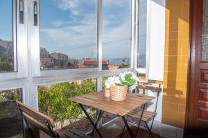 a table and chairs on a balcony with windows at Laxes do Mar in Baiona