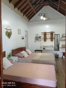two beds in a room with white walls at Puriran's Hometel in Basco