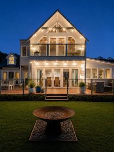 a large house with a table in the front yard at Casa Con Vista Luxury Waterfront Home, Sleeps 10 in Hobart +34 photos