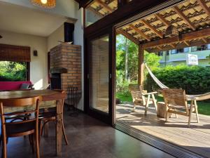 a room with a patio with a table and chairs at Surf a poucos passos do mar, casa com lareira in Garopaba