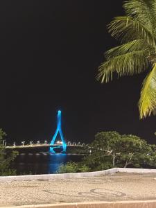 a blue bridge in the water at night at Temporada Ilhéus Centro in Ilhéus