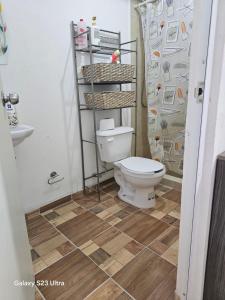a bathroom with a toilet and a shower curtain at La comodidad a tu alcance in Bata +13 photos