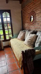 a bedroom with a bed and a brick wall at Casalma hospedaje y bienestar in Salta