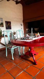 a red table and chairs in a room at Casalma hospedaje y bienestar in Salta