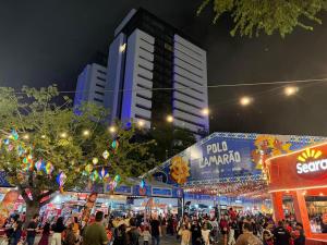 a crowd of people walking down a street at night at White Life in Caruaru