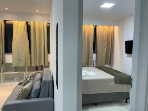 a bedroom with a bed and a couch and windows at White Life in Caruaru