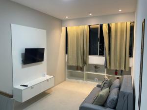 a living room with a couch and a flat screen tv at White Life in Caruaru