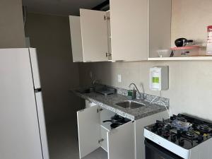 a small kitchen with a sink and a stove at White Life in Caruaru