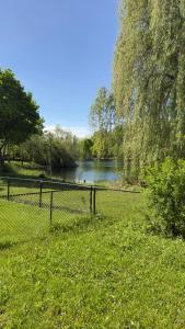 a fence in front of a river with a river istg at Beautiful lake view Basment room in Brampton