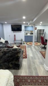 a living room with a couch and a kitchen at Beautiful lake view Basment room in Brampton