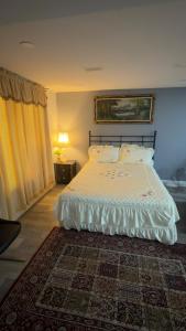 a bedroom with a white bed with a rug at Beautiful lake view Basment room in Brampton