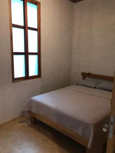 a bedroom with a bed and a window at Fuga Ecolodge casa de campo in Carara +7 photos