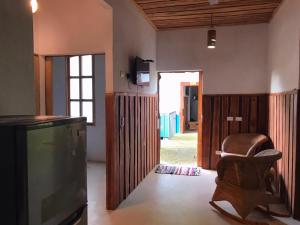 a living room with a tv and a chair at Fuga Ecolodge casa de campo in Carara