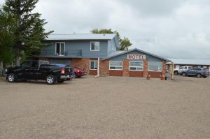 a truck parked in a parking lot in front of a motel at A1 Motel And Campground in Bassano