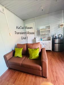 a brown couch in a living room with yellow pillows at Kecai Haven Transient House in Digos +33 photos