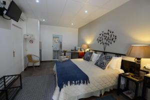 a bedroom with a bed with a blue blanket on it at Carters Rest Guesthouse in Kimberley
