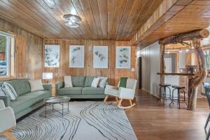 a living room with a green couch and a rug at Hottub Hideaway: Firepit; Sauna; Views; Wildlife in Custer +61 photos