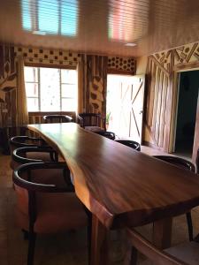 a long wooden table in a room with chairs at Fuga Ecolodge Casa grande in Carara