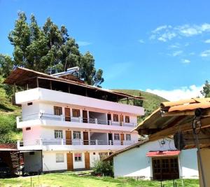 a large white building with trees in the background at Hospedaje Hacienda Norabuena in Recuay