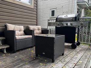 a grill on a deck with two wicker chairs at Character Home near Downtown and 17th Avenue in Calgary