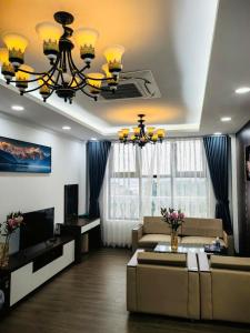 a living room with a couch and a chandelier at Army Hotel in Yen