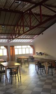 a large room with tables and chairs and windows at Hospedaje Hacienda Norabuena in Recuay
