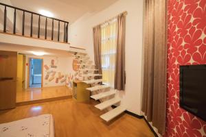 sala de estar con escaleras y TV en Hodua Guest House, en Beigang