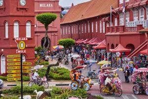 a group of people riding bikes down a city street at klebang Beachfront Homestay I Snooker I Massage Chair I Pool in Malacca
