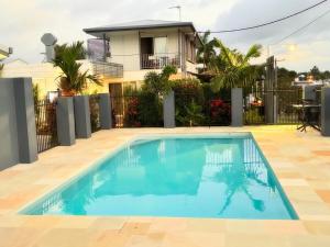 a swimming pool in front of a house at Shady Rest Motel in Gympie
