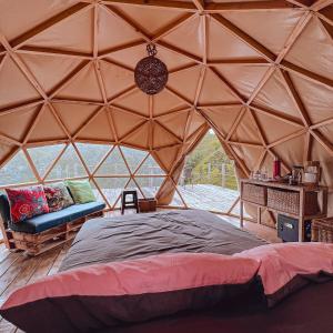 a bedroom in a yurt with a bed and a couch at La Alborada Glamping in Filandia