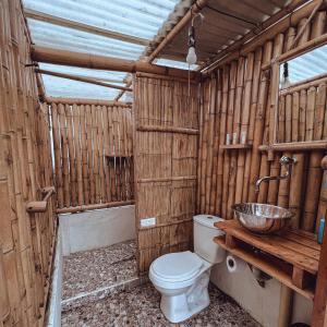 a wooden bathroom with a toilet and a sink at La Alborada Glamping in Filandia +12 photos