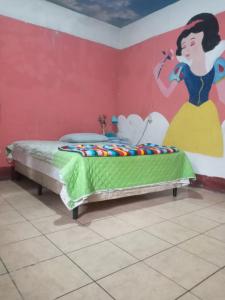 a bedroom with a bed with a painting on the wall at House the Cats in Panajachel