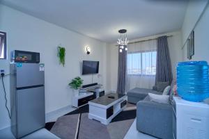 a living room with a couch and a refrigerator at Luxore apartment in Syokimau