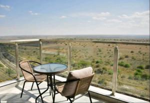a balcony with a table and chairs and a view at Luxore apartment in Syokimau