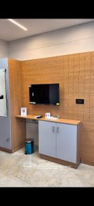 an office with a desk and a tv on a wall at TCS SUITES Chala Bypass Kannur in Thottada