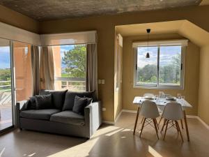 a living room with a couch and a table at Lomas del Real Apart in Colonia del Sacramento