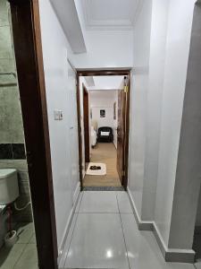 a hallway leading to a room with white walls at Luxore apartment in Syokimau +28 photos