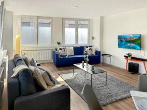 a living room with a blue couch and a table at Loft 24 Stuttgart Zentrales Gruppenloft für 10 Gäste mit PS5 in Stuttgart