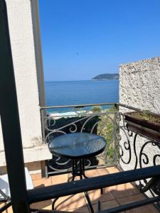 a balcony with a table and a view of the ocean at Obala Ineks in Sutomore