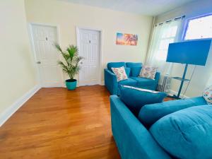 a living room with a blue couch and a plant at CaneView Properties - 3 in Irvington