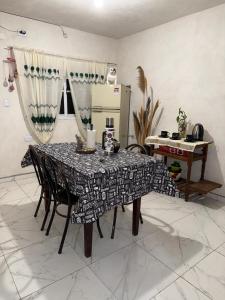 a dining room table with chairs and a kitchen at Runa Huasi in Tinogasta