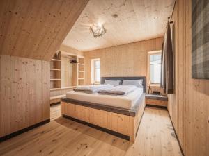 a bedroom with a bed in a room with wooden walls at Modern chalet with sauna, Dein Bichlbach in Bichlbach