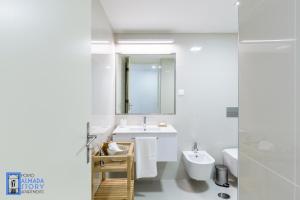 a white bathroom with a sink and a mirror at Almada Story Apartments by Porto City Hosts in Porto